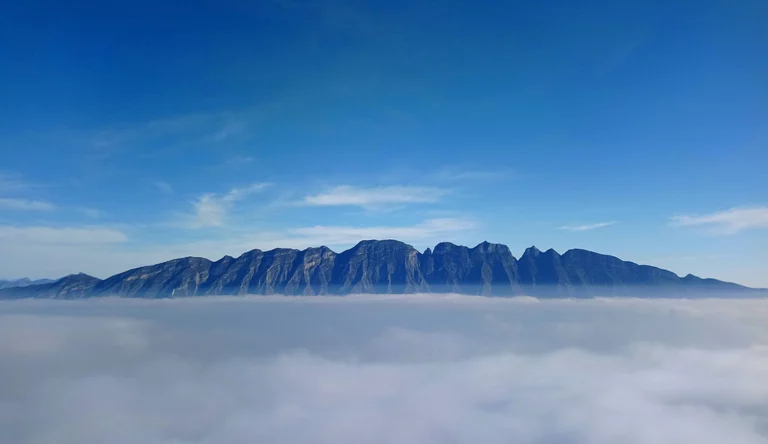 Vista panorámica del Cerro de las Mitras con nubes en primer plano